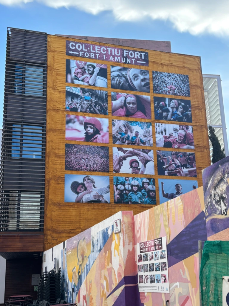 Fachada de un edificio con una exposición de fotos del Col·lectiu Fort sobre los castells catalanes.