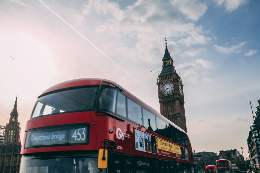 Red double-decker bus driving past the Elizabeth Tower (Big Ben) in London.