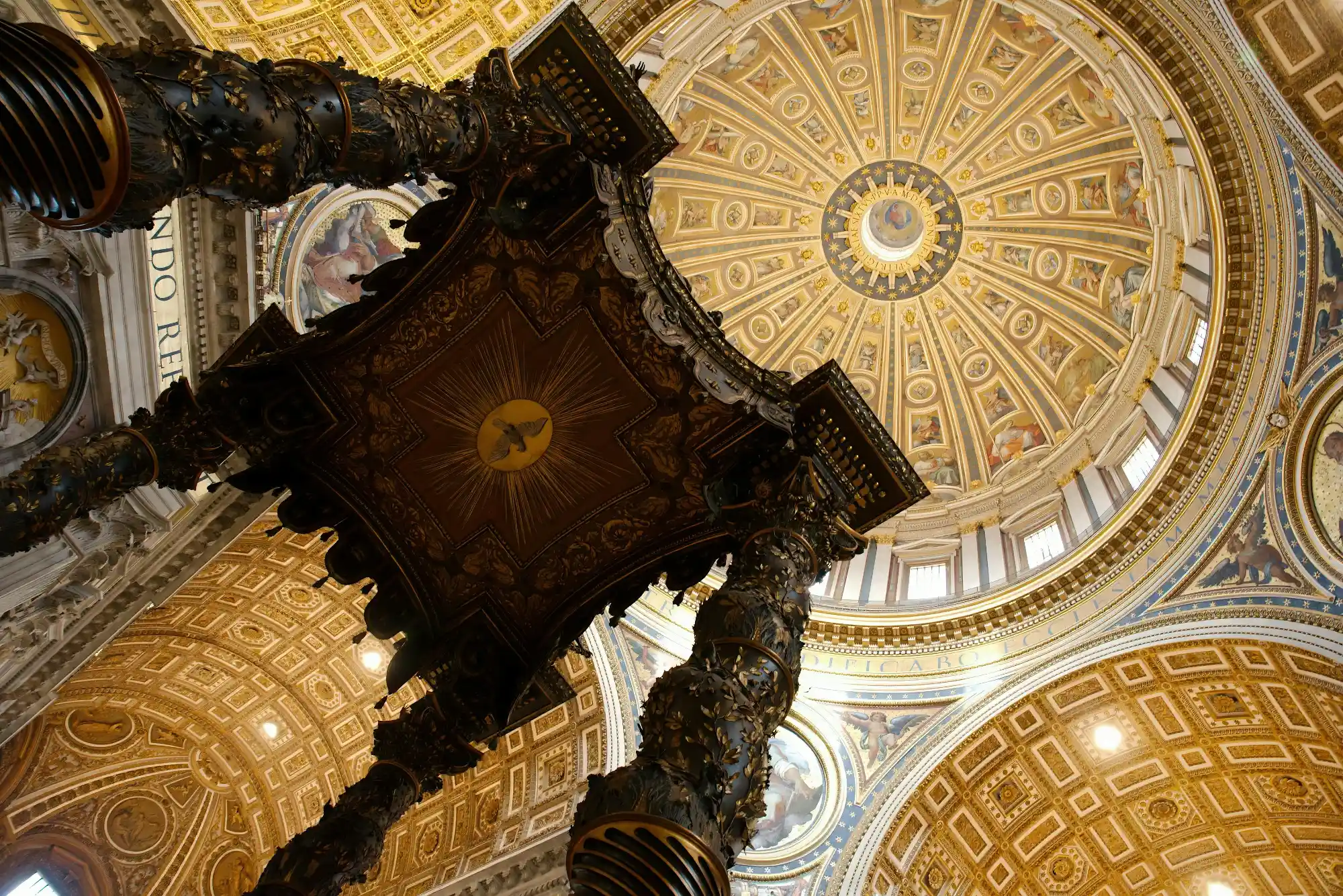 Looking up past Bernini's Baldachin towards the golden, painted dome of St. Peter's Basilica in Rome.